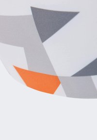 Barevné vzorované látky s velkými šedými a bílými trojúhelníky a akcentem v oranžovém trojúhelníku. Hladká textura, zakřivený tvar na okraji.