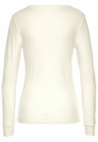 White long-sleeve top with ribbed texture, round neckline, and fitted shape. Features simple cuffs and a smooth finish.