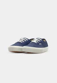 Navy canvas sneakers with white laces, rubber sole, and contrasting white stitching. Features a small logo on the side. Rounded toe design.