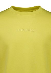 T-shirt in cotone giallo con scollo rotondo, con il nome del marchio "LINDBERGH" in rilievo sul petto. Tessuto liscio.