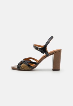Sandal con tacco alto in vernice nera, con dettagli intrecciati in beige, punta aperta, cinturino alla caviglia regolabile e tacco a blocco.