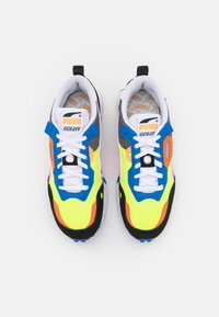 Baskets colorées avec une tige en mesh ornée d'accents jaune néon, noir, bleu et orange. Des lacets blancs et une languette rembourrée complètent le design.