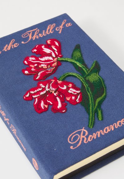 Copertina di libro in tessuto blu con fiori ricamati rossi e bianchi e testo corsivo rosa che recita "Il brivido di un romanzo."