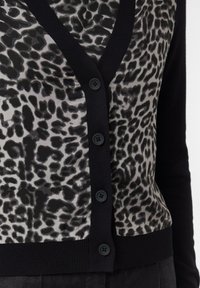 Knopf-up Strickjacke mit einem Leopardenmuster in Grau und Schwarz, einem einfarbigen schwarzen Rippabschluss und sechs schwarzen Knöpfen.