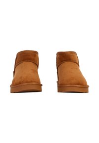 Rettede ankelst�øvler i tan-kamelnubuck med rund tå, syninger og gummisål. Glat tekstur med minimal dekoration.