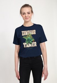 Námo�řnické tričko s ilustrací dinosaura a textem "KROTITEL DINOSAURŮ." Krátké rukávy a uvolněný střih, vyrobeno z měkké bavlněné směsi.