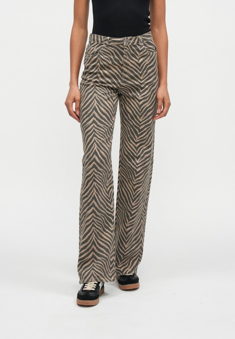 Hnedé a béžové rozšírené nohavice so vzorom cikcak, vyrobené z mäkkej látky, s prednými vreckami a priliehavým pásom.