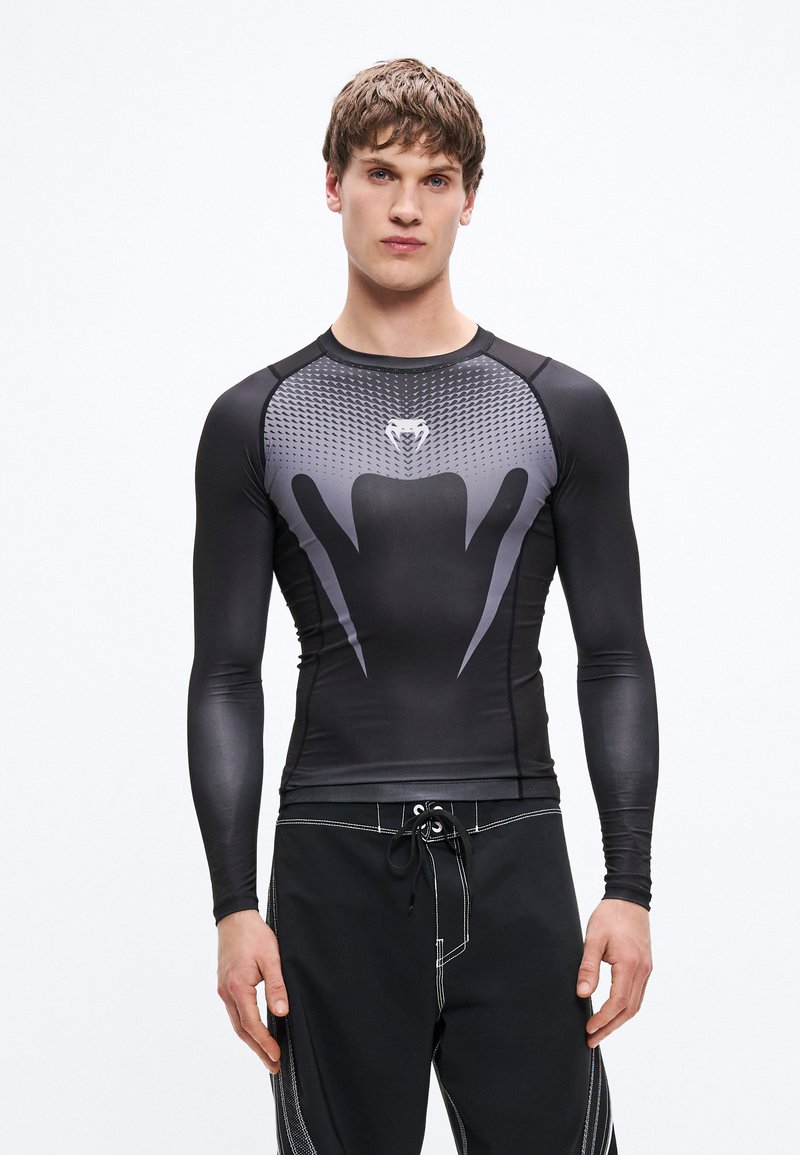 Czarna i szara sportowa koszulka z długim rękawem, z wzorzystą górną częścią, nowoczesnym designem oraz gładkim, elastycznym materia�łem.