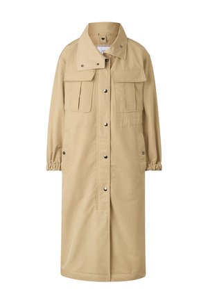 Lang beige frakke med trykknapper foran, to brystlommer med klap, sidelommer, elastiske manchetter og en høj krave.
