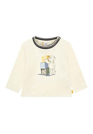 Crème lange mouw shirt met een zwart gestreepte halslijn en een speelse beerafbeelding die gekleurde blokken op elkaar stapelt. Zacht katoen.