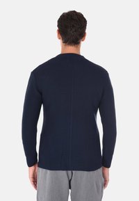Maglione a maglia blu navy con un motivo testurizzato, collo rotondo e maniche lunghe. Presenta una cucitura centrale sul retro.