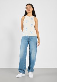 Cream ribbed tank top with blue bow patterns, paired with light blue wide-leg jeans and white sneakers. Simple, casual style.