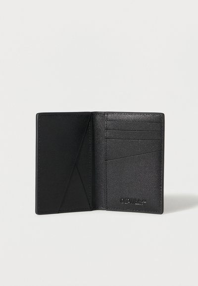 Portefeuille bifold en cuir noir ouvert montrant trois emplacements pour cartes, deux poches inclinées et un logo de marque embossé sur le côté droit.