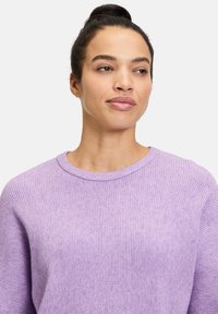 Helllila geripptes Sweatshirt mit Rundhalsausschnitt, überschnittenen Schultern und weicher Textur. Keine sichtbaren Muster oder Hardwaredetails.