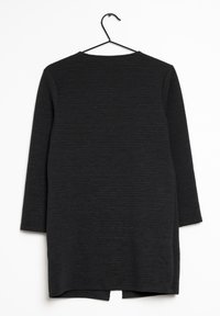 Schwarz geripptes Kleid mit langen Ärmeln, ausgestattet mit einem Rundhalsausschnitt und einem modischen Schnitt bis zum Knie, der seitliche Schlitze für mehr Bewegungsfreiheit bietet.