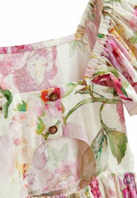 Vestido floral con tejido suave y ligero en color crema, que presenta patrones de flores en rosa y verde, mangas acampanadas y botones de madera.