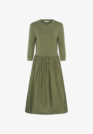 Olíva zöld ruha kerek nyakkivágással és háromnegyedes ujjakkal, összegyűrt derékkal és teljes, lebegő szoknyával.