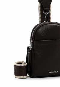 Dark brown textured leather sling bag with silver zipper, black and beige adjustable strap, and EMILY & NOAH logo on front.