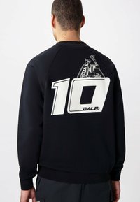 Sudadera negra con cuello redondo, que presenta un gran número blanco "10" y un diseño gráfico en la parte posterior. Tejido suave, puños y bajo acanalados.