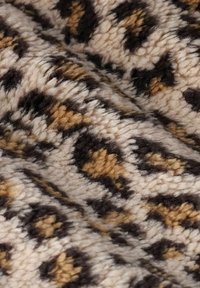 Zacht gestructureerde stof met een close-up leoprint patroon in beige, bruin en zwarte tinten.