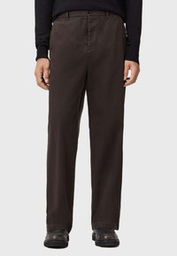 Bruine, lichte, rechtgesneden broek met een knoopsluiting, schuine zijzakken en een gladde stoftextuur.