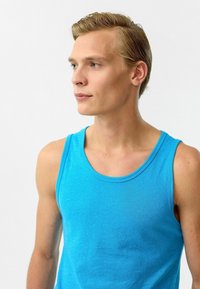 Blauwe tanktop van zachte stof, met een ronde halslijn en brede schouderbanden. Gladde textuur met een effen kleur ontwerp.