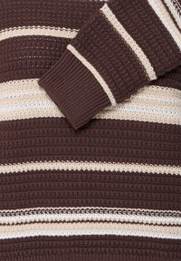 Pull en maille avec des rayures horizontales texturées marron et beige et un poignet côtelé sur la manche pliée.