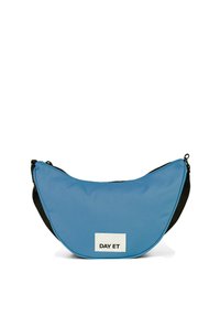 Borsa a tracolla in tessuto blu con forma a mezzaluna, dettagli neri e un'etichetta bianca con la scritta "DAY ET". Texture liscia e chiusura con zip.