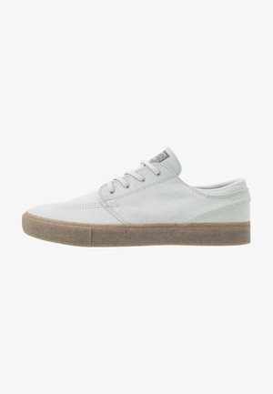 Sneaker basse in camoscio grigio chiaro con lacci bianchi, logo Nike cucito e suola in gomma.