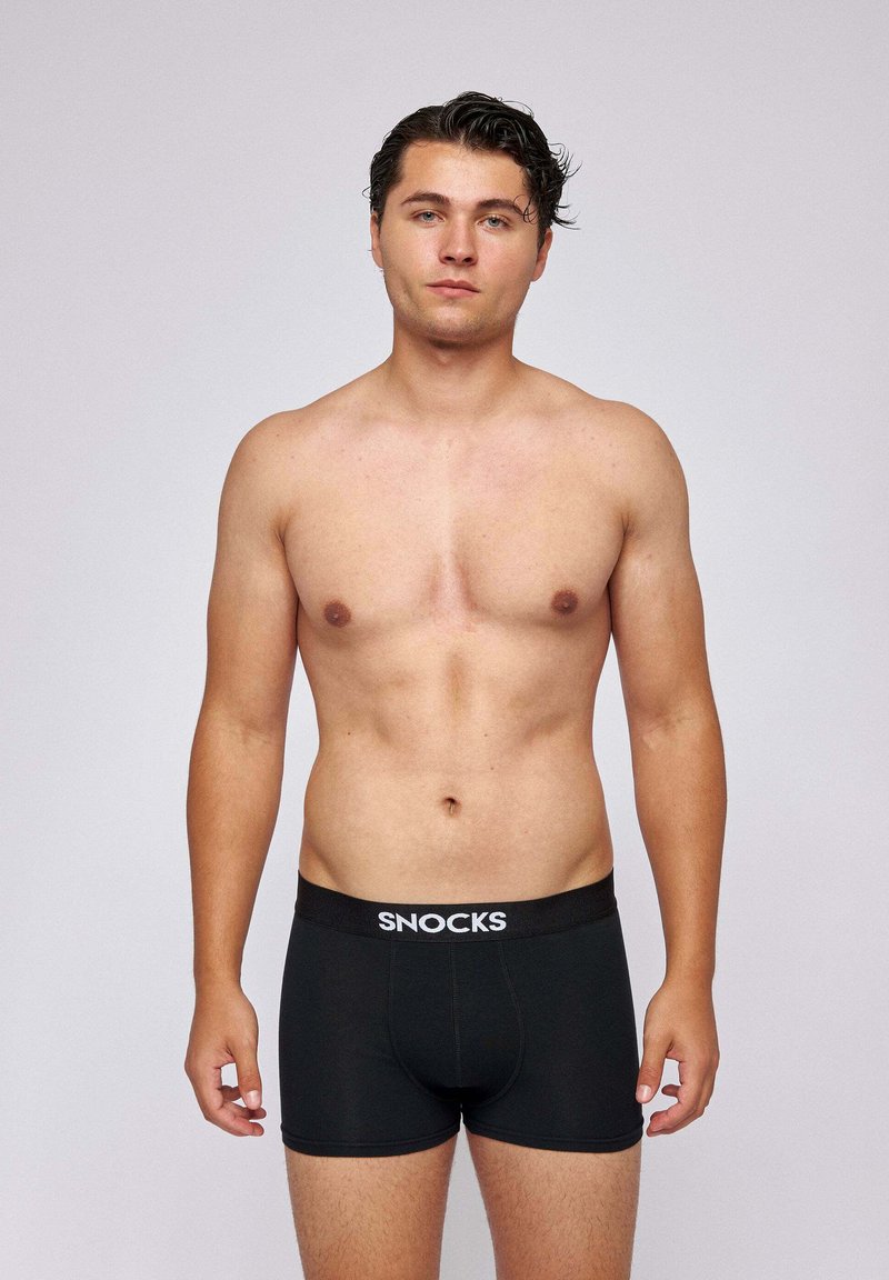 Black boxer briefs with a SNOCKS branded elastic waistband, featuring a fitted design and smooth fabric texture.