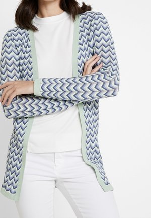 Cardigan aderente in maglia con un motivo a zigzag blu e bianco, con accenti verde menta lungo i bordi. Maniche lunghe, design aperto sul davanti.