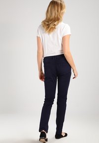 Granatowe spodnie slim-fit wykonane z mieszanki bawełny, z kieszeniami, gładką teksturą i klasycznym fasonem pasa.