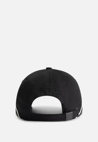 Black cap with a cotton material, curved brim, and adjustable strap. Features "TOMORROWLAND" embossed on the rear and white accent stripes.
