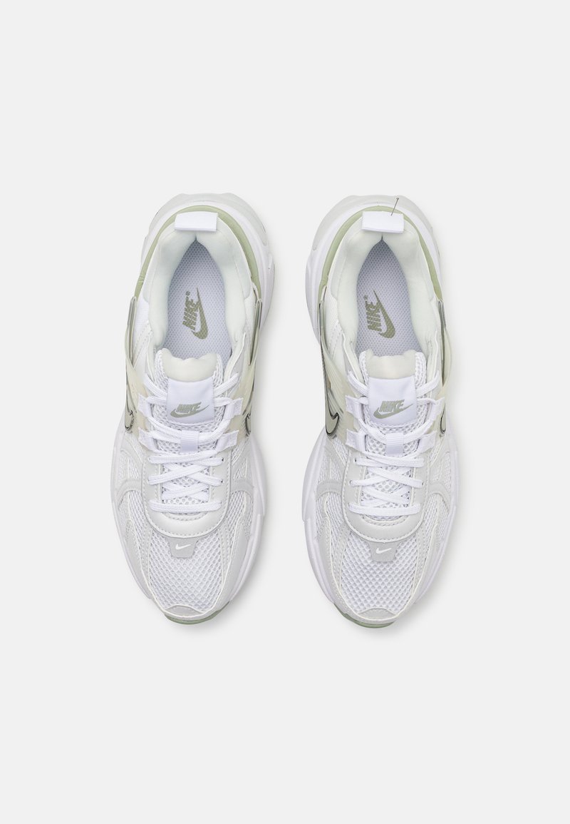 Chaussures de sport blanches avec des empiècements en maille et en synthétique, mettant en avant un accent vert translucide, un col rembourré et un système de laçage.