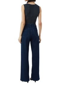 Donkerblauwe wijde jeans met hoge taille, twee achterzakken en een getailleerde pasvorm. Katoenen materiaal met een gladde textuur.