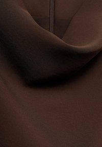 Tejido marrón con una textura suave, que presenta un brillo sutil y un drapeado elegante. Una cremallera es visible a lo largo del borde, realzando su diseño.