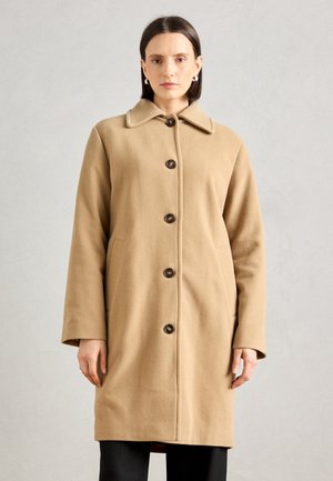 Beige wollen jas met een kraag, sluiting met knopen aan de voorkant, zijzakken en lange mouwen, met donkere knopen als accenten.