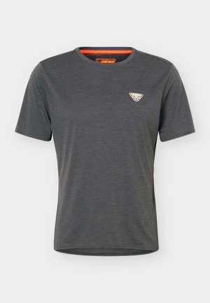 T-shirt gris foncé à manches courtes avec col rond, petit logo triangulaire clair sur la poitrine gauche et étiquette orange à l’intérieur du col.