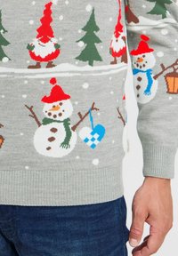 Grauer gestrickter Pullover mit Schneemännern, Weihnachtsmann und Weihnachtsbäumen in Rot, Grün und Blau. Rippbündchen und Saum, mit einer weichen Textur.