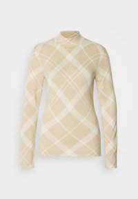 Bluză bej cu mâneci lungi și guler înalt, cu model crem în formă de diamant și material texturat, evidențiind o siluetă mulată.