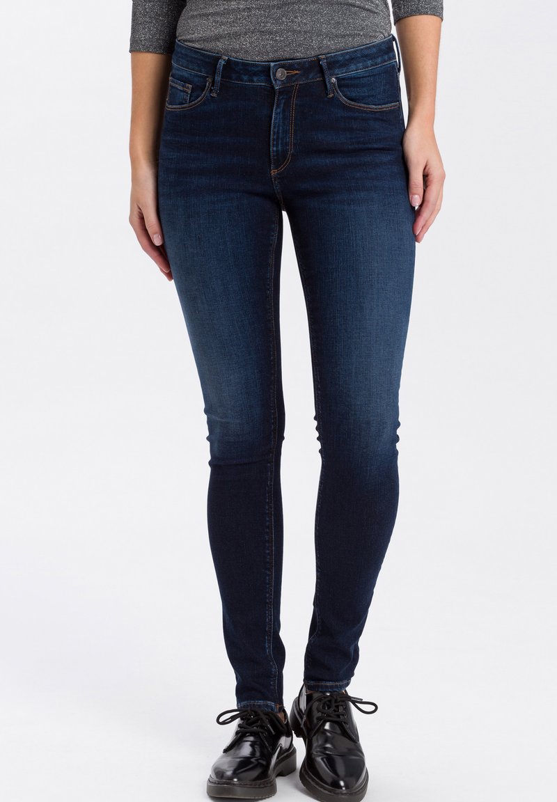 Skinny jeans in een donkere spijkerstof met een gladde textuur, inclusief voorzakken, riemlussen en contrasterende stiksels.