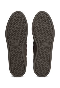 Ciemnobrązowe gumowe podeszwy butów z teksturowanym wzorem diamentu. W centrum znajduje się etykieta z logo marki. Całość ma płaski design.