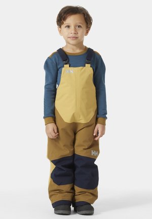 Mamelucos infantiles impermeables en amarillo y marrón, con detalles en azul marino. Cuenta con tirantes ajustables y un logo en la parte frontal.