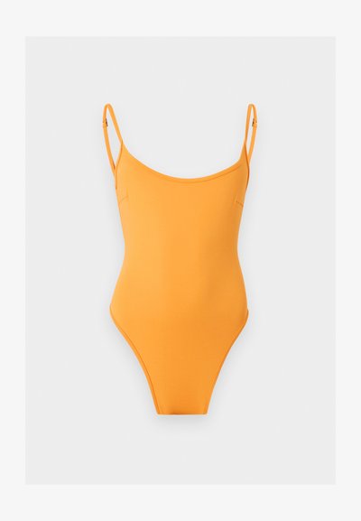 Φωτεινό πορτοκαλί ολόσωμο μαγιό με λεπτές ρυθμιζόμενες τιράντες σε μονόχρωμο ανοιχτό γκρι φόντο.