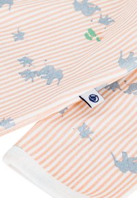 Ύφασμα με ανοιχτό πορτοκαλί και λευκές ρίγες, διακοσμημένο με παιχνιδιάρικους μπλε ελέφαντες και πράσινες λεπτομέρειες. Μαλακή υφή με ριμπ λευκή τρέσσα και ετικέτα με το λογότυπο της μάρκας.