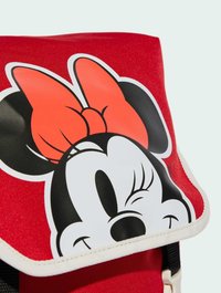 Zaino in tessuto rosso con un grande motivo stampato di Minnie Mouse, dotato di un fiocco nero e rosso. Include bordature bianche e dettagli neri.