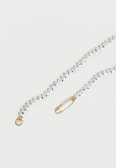 Κολιέ με μικρές λευκές πέρλες και μικροσκοπικές μπλε χάντρες, με χρυσό κούμπωμα ασφαλείας σε λευκό φόντο.