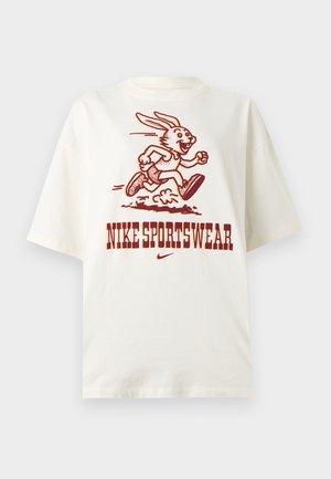 Λευκή μπλούζα με φανταστικό λαγουδάκι που τρέχει και το κείμενο "NIKE SPORTSWEAR" με έντονα κόκκινα γράμματα κάτω από την εικόνα.