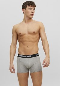 Graue Boxershorts mit einem schwarzen elastischen Bund, der mit weißem "JACK & JONES"-Branding versehen ist. Der Stoff wirkt weich und hat eine figurbetonte Passform.