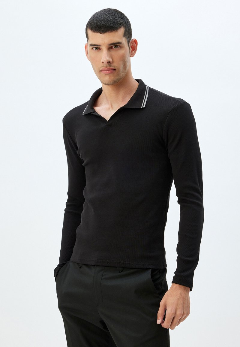 Svart långärmad polo t-shirt i ribbat tyg, med en krage som har kontrasterande vita ränder och en slim fit-design.